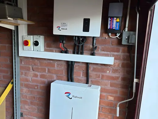 A hybrid inverter and battery mounted on an external brick wall